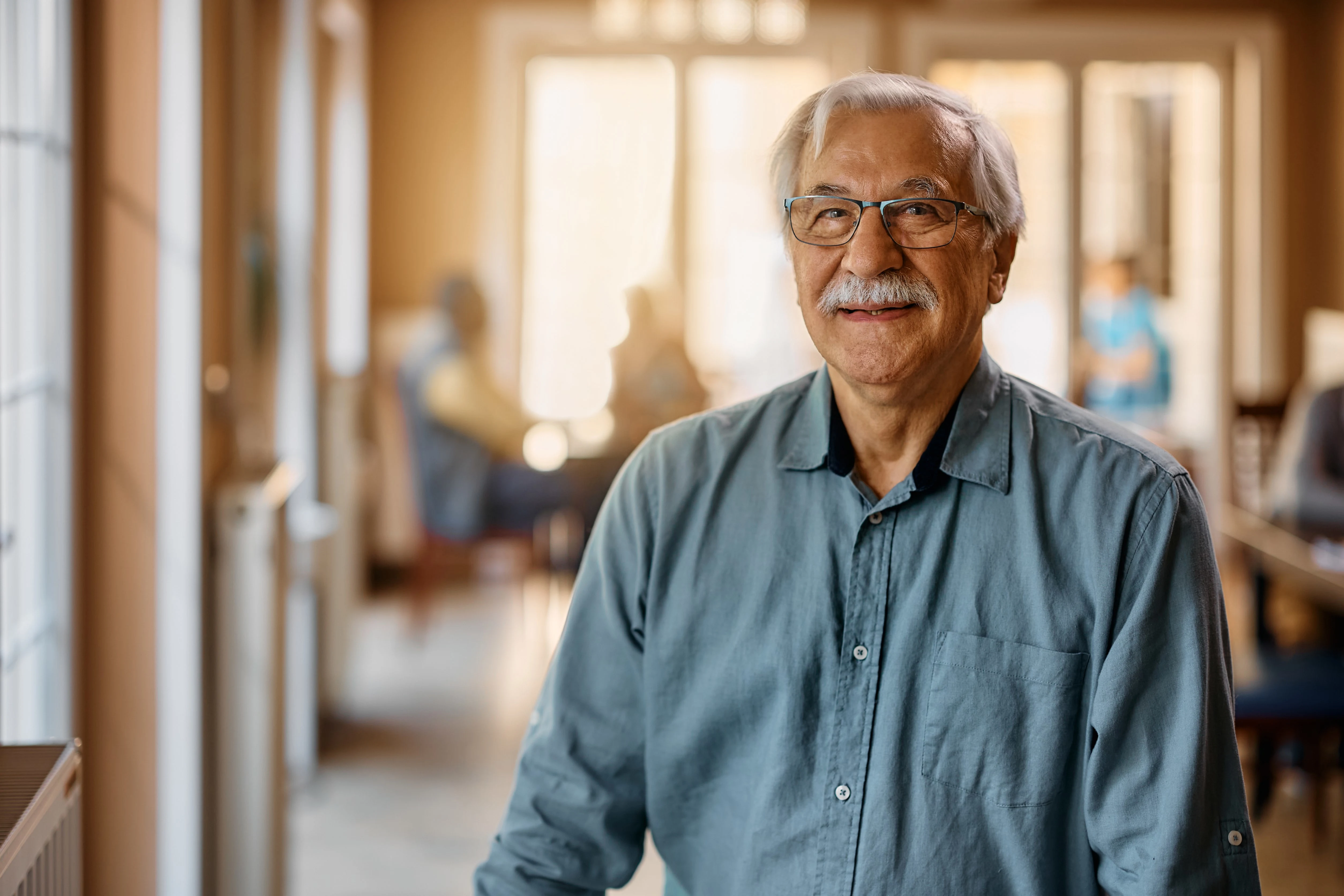 Smiling senior man enjoying a comfortable and caring environment in his assisted living community.